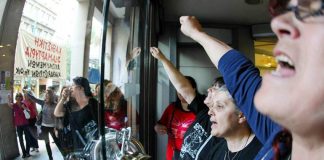 Sacked cleaners occupying the Greek Finance Ministry barricaded themselves in and chained the doors to keep the riot police out. Photo credit: MARIAS LOLOS