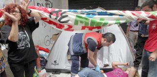 One of the injured cleaners being treated by an ambulance crew following the riot police attack