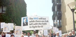 GPs and their supporters with their main banner showing that they are determined to fight to maintain and defend the NHS