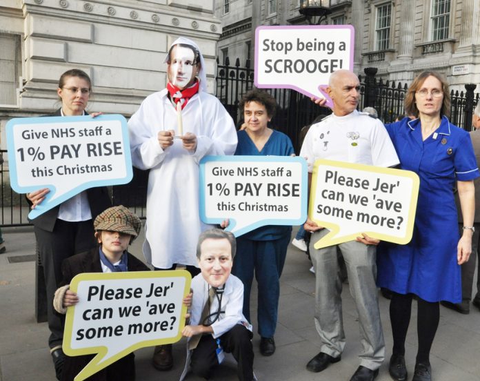 Health workers depicting Prime Minister Cameron and Health Secretary Hunt as Scrooges over the government’s refusal to pay the 1% pay rise to all NHS workers