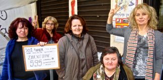 The group of sacked women cleaners at the Camp of Struggle. One of them holds the tablet stating the 301 days of the fight