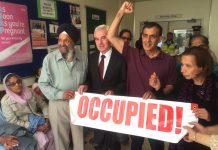 Labour MP for Hayes and Harlington John McDonnell holding the occupied banner with workers from Southall inside the maternity department