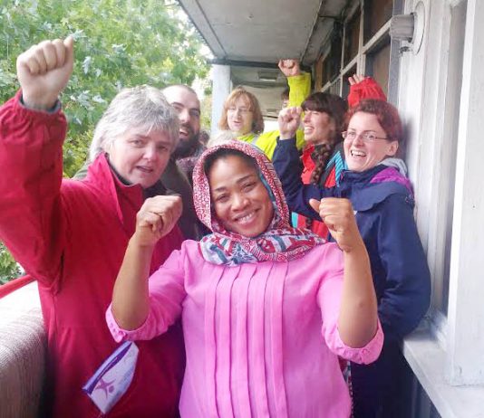Aminata Sellu (centre) celebrates with supporters after successfully barring the way to bailiffs and the police