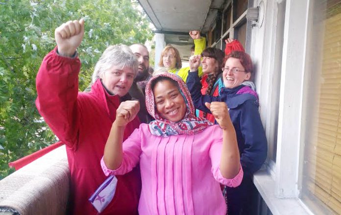 Aminata Sellu (centre) celebrates with supporters after successfully barring the way to bailiffs and the police