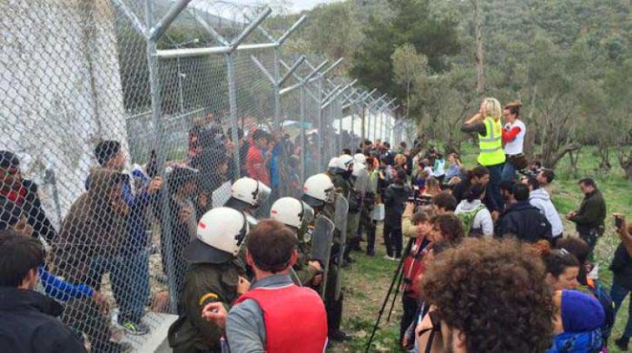 Refugees in the Moria camp in Greece protest. They are in a prison until they are to be moved out of Greece by the police and army. Photo credit: left.gr