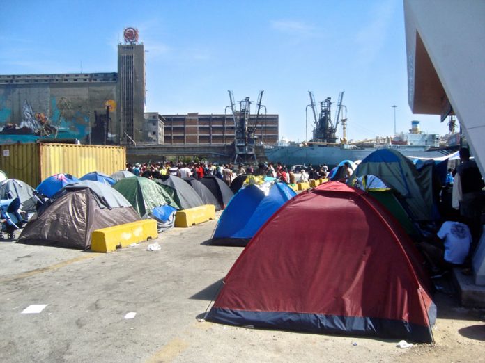 Refugees camp in the port of Piraeus – another refugee has died after being seriously injured by a police vehicle