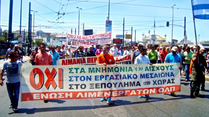 Striking dock workers march in the port of Piraeus