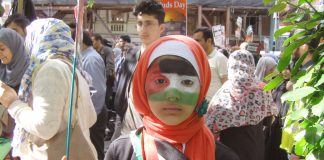 A young girl on the march proud to display the colours of the Palestinian flag