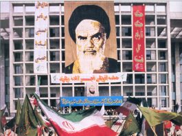 Portrait of Ayatollah Ruhollah Khomeini above a rally in Tehran marking the dispatch of forces to the front