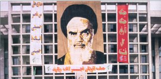 Portrait of Ayatollah Ruhollah Khomeini above a rally in Tehran marking the dispatch of forces to the front