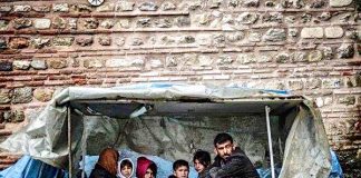 Refugee family – trying to keep alive from cold in a flimsy shelter. Photo credit: Panos Papanikolaou