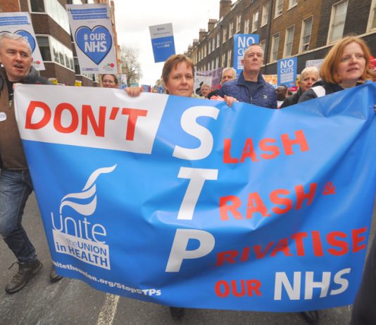 Unite members marching against the STP plans – the budget promises to speed up the STP attack on the NHS