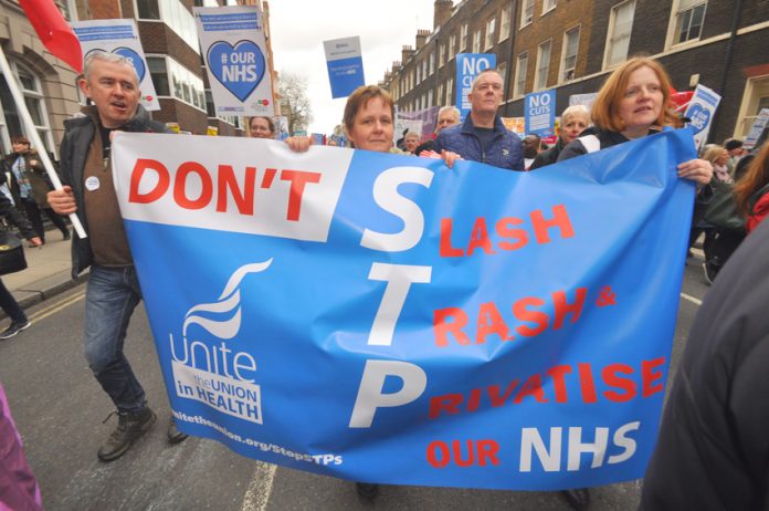 Unite members marching against the STP plans – the budget promises to speed up the STP attack on the NHS