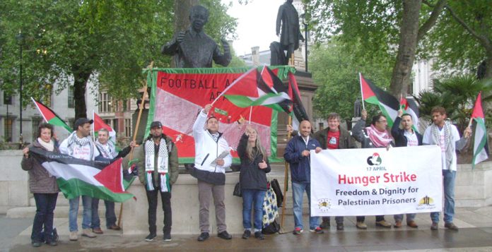 Palestinian AYSAR SHAMALLAKH (centre in white jacket) on hunger strike in solidarity with over 1,600 hunger-striking Palestinian prisoners in Israeli jails. Picture shows Aysar and supporters demonstrating in Parliament Square on Wednesday evening