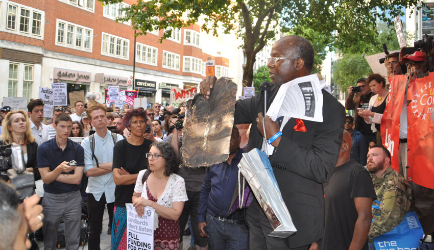 At a rally last Friday at the Department for Communities and Local Government a resident from north Kensington holds up a piece of charred cladding that had fallen from Grenfell Tower during the blaze