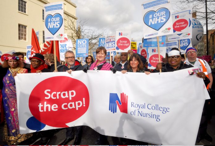Nurses marching to defend the NHS demanding the 1% pay cap be scrapped