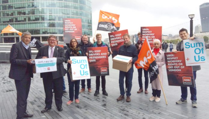 London Assembly member UNMESH DESAI (left) receives the over 100,000-strong petition from GMB official STEVE GARELICK outside City Hall on Monday morning