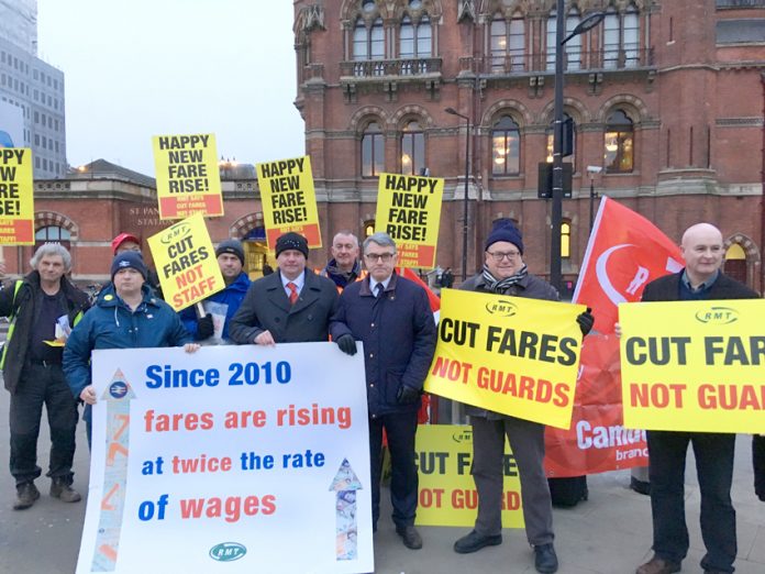 Train staff joined forces with furious commuters demonstrating at stations across the country against massive rail fare hikes which came in yesterday morning – MICK CASH (centre) RMT General Secretary, who joined the King’s Cross protest, called for the c