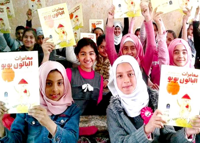 Young Iraqi girls hold copies of ‘The Adventures of Booboo the Balloon’. They are now writing their own stories