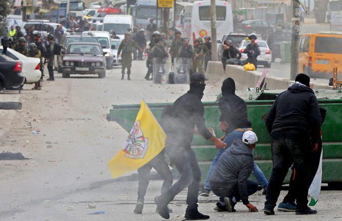 Palestinian youth clash with Israeli forces at the Qalandia checkpoint outside Ramallah