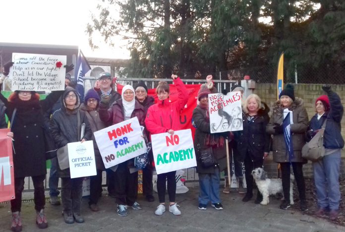 Teachers were joined by parents outside The Village School in Kingsbury, north west London, on their picket line yesterday morning