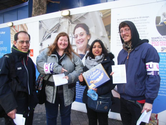 Striking university lecturers on the picket line at Imperial College are presented with a box of biscuits by a supporter