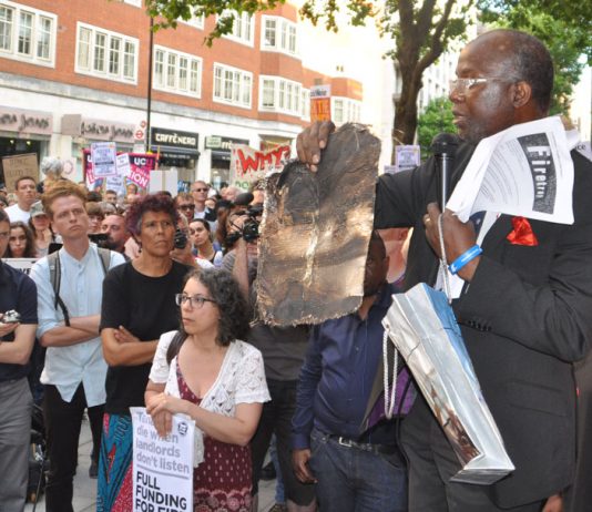 Resident of North Kensington holds a piece of the charred cladding from the Grenfell Tower inferno – building materials will still not be rigorously tested to see if they are flammable as the Tories have refused to rule out ‘desktop assessments’