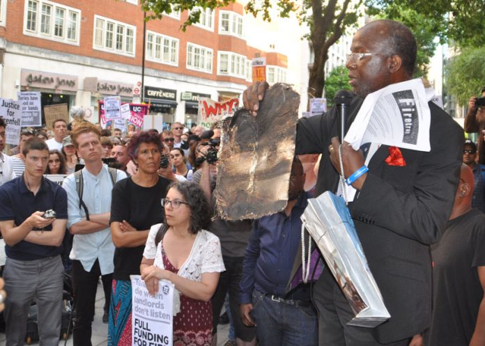 Resident of North Kensington holds a piece of the charred cladding from the Grenfell Tower inferno – building materials will still not be rigorously tested to see if they are flammable as the Tories have refused to rule out ‘desktop assessments’