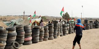 Palestinian youth prepare to set fire to piles of tyres on yesterday’s massive ‘Great March of Return’ on the Gaza border