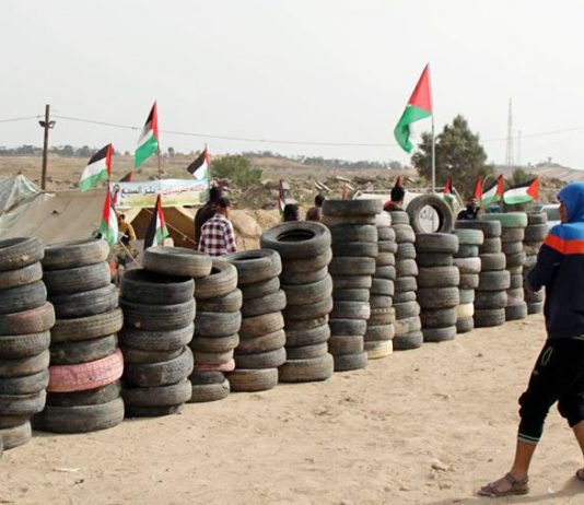 Palestinian youth prepare to set fire to piles of tyres on yesterday’s massive ‘Great March of Return’ on the Gaza border
