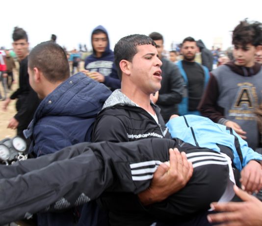 A Palestinian victim of Israeli sniper fire on the Gaza border is carried to safety