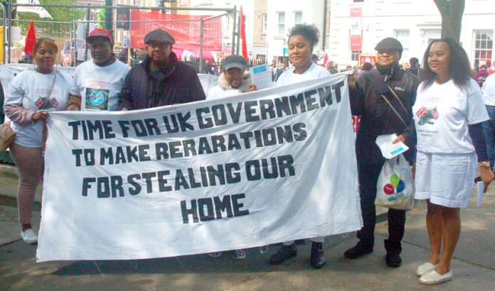 Chagos Islanders with their banner demanding reparations from the government for the stealing of their homeland