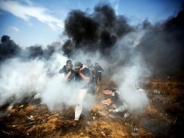 Erekat Slams US Complicity With Israel! Young Palestinian demonstrators escaping the bombardment of tear gas and bullets from Israeli Defence Forces at the Gaza-Israel border fence