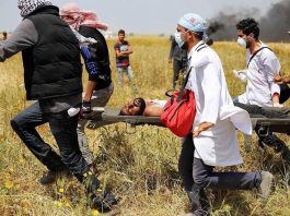 Palestinian wounded by Israeli sniper fire on the Gaza border is carried to safety
