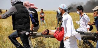 Palestinian wounded by Israeli sniper fire on the Gaza border is carried to safety