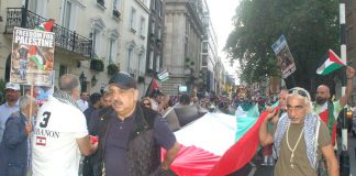 The march sets off, lead by a huge Palestinian flag, from outside the Saudi embassy in central London