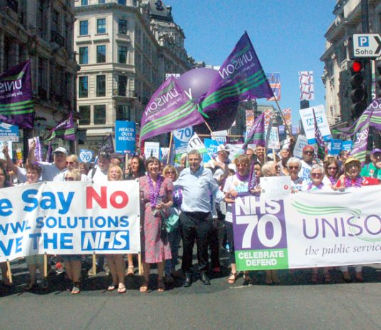 Unison members on the NHS 70th anniversary demonstration in London with (left) strikers from the Wrightington, Wigan & Leigh hospital over plans to transfer their jobs to a private company