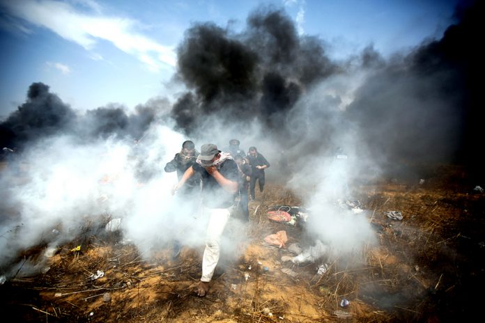 Palestinians demonstrating on the Gaza border with Israel under attack from Israeli armed forces