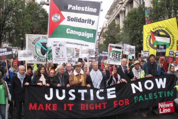 Palestinian Ambassador MANUEL HASSASSIAN (centre, in cap) on a march in London last November to condemn the Balfour Declaration
