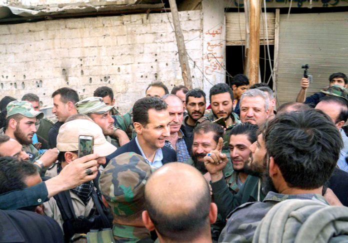Syrian President BASHAR AL-ASSAD greets troops after the liberation of Ghouta province