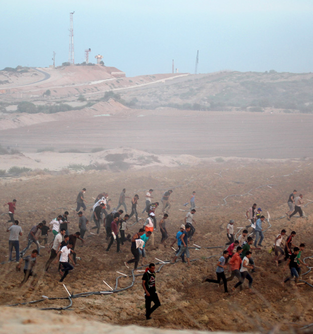 Palestinians on the Great March of Return on the Gaza border with Israel protest under the shadow of Israeli military observation posts and spy towers – farmers have now been fired on from these posts