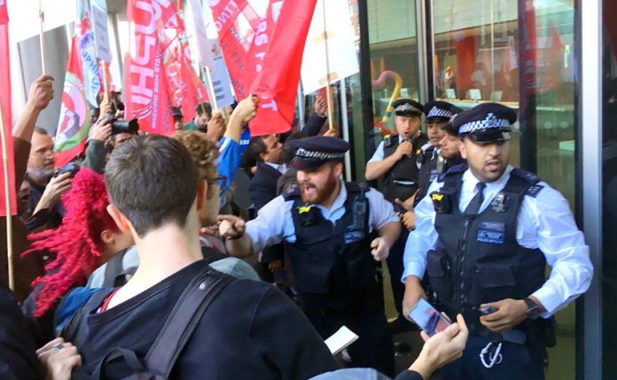 Police outside the Uber HQ desperate to stop Uber drivers and their supporters from entering the building