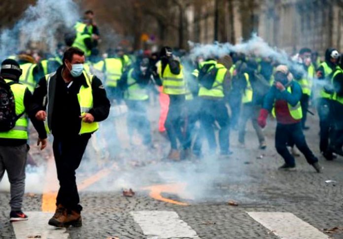 French Yellow Vest demonstrators  in Paris where the French riot police used tear gas rubber bullets and water cannon against them