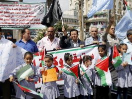 Children at the front of a protest in Ramallah against the cut in aid to UNRWA