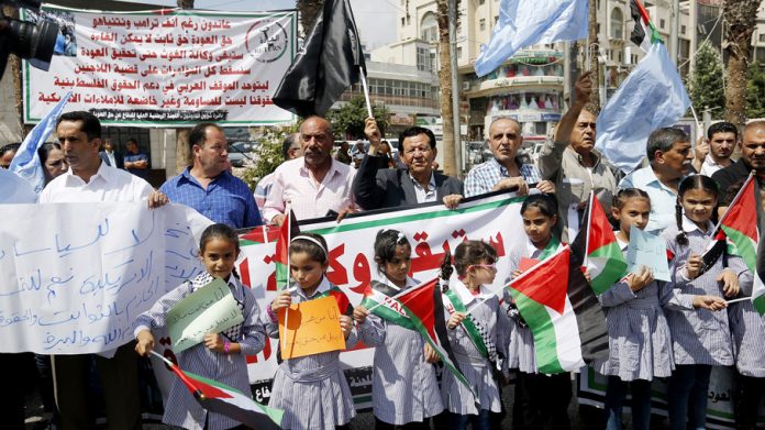 Children at the front of a protest in Ramallah against the cut in aid to UNRWA