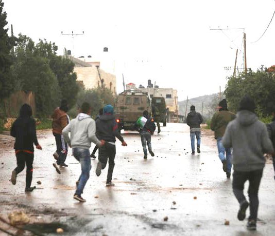 Palestinian youth battle with Israeli troops and settlers on the West Bank