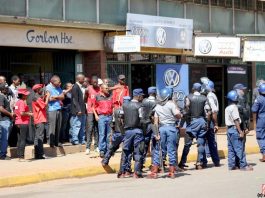 Riot police and workers clash outside the ZCTU offices after protests against Zimbabwean government tax hikes last October