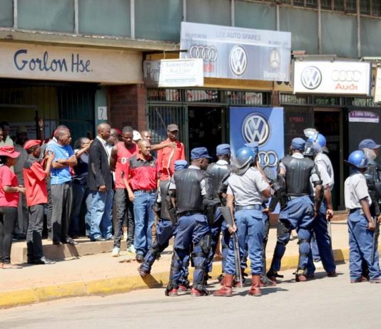 Riot police and workers clash outside the ZCTU offices after protests against Zimbabwean government tax hikes last October