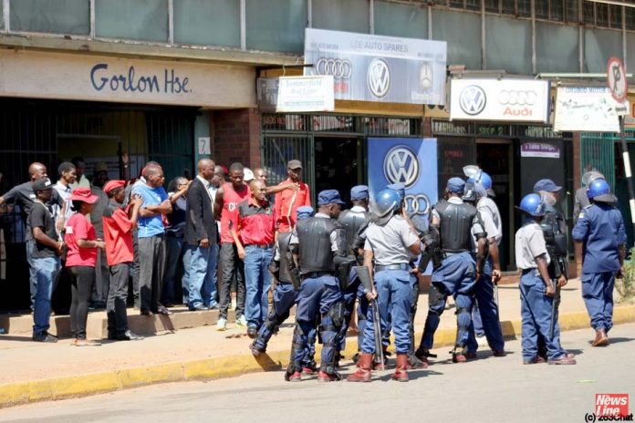 Riot police and workers clash outside the ZCTU offices after protests against Zimbabwean government tax hikes last October