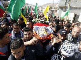 The body of Hamdi Nassan from the village of al-Mughayir, who was shot dead by Israeli settlers, is carried to his last resting place